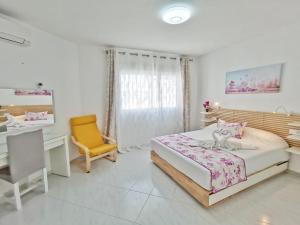 een slaapkamer met een bed, een bureau en een stoel bij Casa Higuera in Nerja