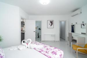 a white bedroom with a bed with a bow on it at Casa Higuera in Nerja