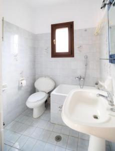 a white bathroom with a toilet and a sink at Μariza's escape in Afissos +39 photos