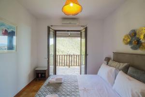a bedroom with a bed and a large window at Μariza's escape in Afissos