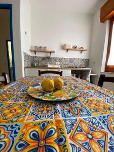 une table avec une plaque de citrons sur celle-ci dans l'établissement A Patedda, à Favignana