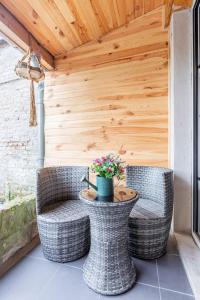 een patio met 2 rieten stoelen en een tafel met bloemen bij fee moi rêver 
