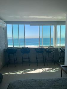 Habitación con sillas y vistas al océano. en Studio Avenida Atlântica, en Río de Janeiro