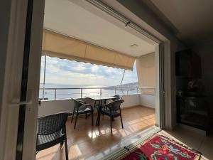 a balcony with a table and chairs and a view of the ocean at Lovely 2 bedroom apartment with a great sea view in Sarandë