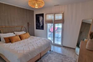 瑞維尼亞克的住宿－La Panacée，一间卧室设有一张大床和一个窗户。