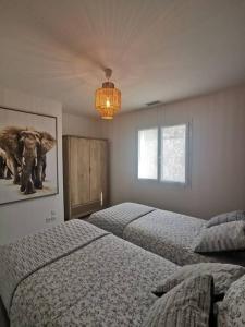 瑞維尼亞克的住宿－La Panacée，一间卧室配有两张床,一张大象的照片