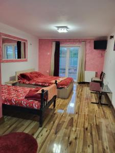 a room with two beds and a desk and a television at Miselin Apartmani in Vladičin Han