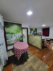 ein Wohnzimmer mit einem Tisch und einem Gemälde an der Wand in der Unterkunft Miselin Apartmani in Vladičin Han