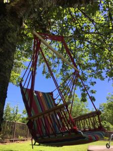 Camping La Ferme de Perdigat في Limeuil: أرجوحة معلقة من شجرة في الحديقة