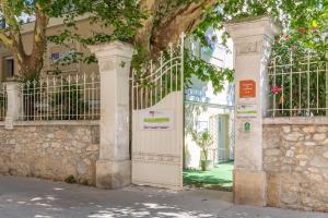 un accès à un bâtiment avec une porte et un arbre dans l'établissement Résidence Les Cordeliers, à Avignon