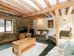 uma sala de estar com um sofá e uma mesa em Redstart Cottage em Leominster