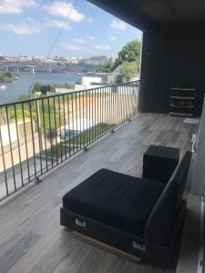 balcón con sofá y vistas al río en Douro ap, en Valbom