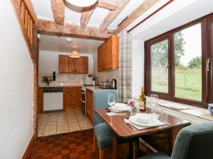 cocina y comedor con mesa y sillas en Redstart Cottage, en Leominster