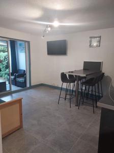 a living room with a table and chairs and a television at Logement plage in Saint-Cyprien