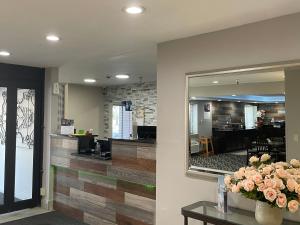 a lobby with a mirror and flowers on a table at La Quinta Inn by Wyndham Cincinnati North in Springdale