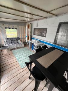 Una habitación con una mesa y una cama en un remolque en Przyczepa HOBBY - 2 minuty od Zatoki, przy wydmach, Kemping FlowCamp en Jastarnia