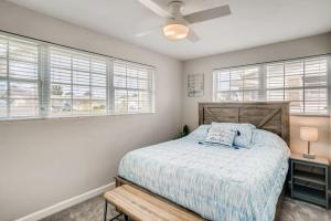 a bedroom with a bed and two windows at Cresting Wave Cottage by the Sea in Ormond Beach