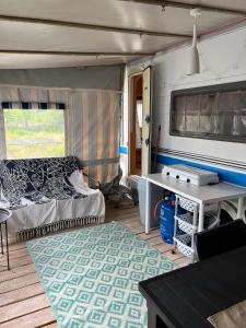 Habitación con cama y mesa en un remolque en Przyczepa HOBBY - 2 minuty od Zatoki, przy wydmach, Kemping FlowCamp en Jastarnia