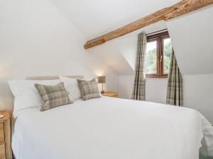 een slaapkamer met een wit bed en een raam bij Field Fare in Leominster