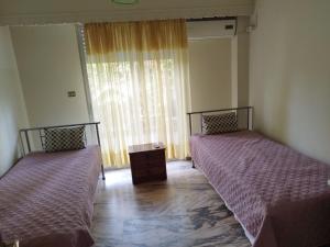 two beds sitting in a room with a window at Vacations in Patra in Patra