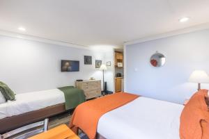 een slaapkamer met 2 bedden, een bureau en een tafel bij Mountainside Inn 103 Hotel Room in Telluride