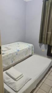 2 camas individuales en una habitación con ventana en Ponta Verde, en Maceió