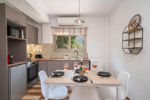 a kitchen with a table with chairs and wine glasses at Mirabilia Apartment in Sami