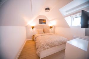 a white bedroom with a bed and a window at Aviva in Pacy-sur-Eure