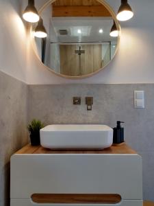 a bathroom with a white sink and a mirror at Domki Pod Lasem - Domek Sosnowy in Stronie Śląskie