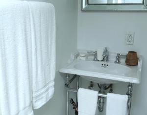 a bathroom with a white sink and towels at Harpoon House in Southampton