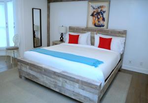 um quarto com uma grande cama de madeira com almofadas vermelhas e azuis em Harpoon House em Southampton