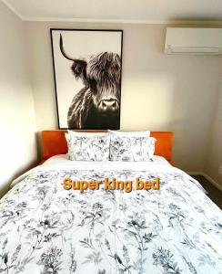 ein schwarz-weißes Bild einer Kuh auf einem Bett in der Unterkunft Aucktons house in Auckland