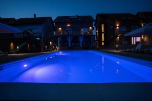 una piscina illuminata di notte di Villa Biser Dunava a Vukovar