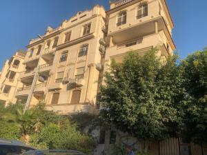 ein großes weißes Gebäude mit Bäumen davor in der Unterkunft Apartment with a private garden in New Cairo in Kairo