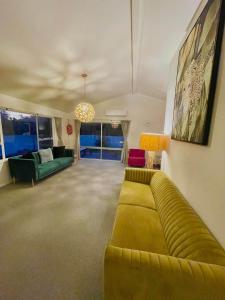 una sala de estar con un sofá verde en una habitación en Aucktons house en Auckland