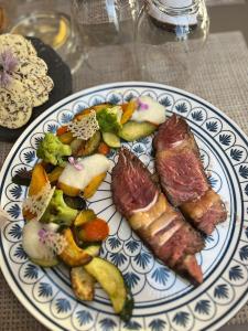 un plato de comida con carne y verduras en una mesa en Le Cro-Bidou, en Bernex