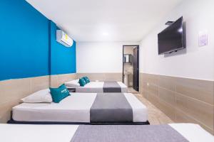 Habitación con 3 camas y TV de pantalla plana. en Hotel Cuchara de Palo Ayenda, en Santa Marta