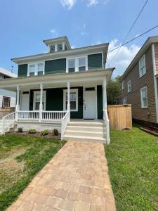 a green house with a white porch and a fence at Cozy Portsmouth Retreat 2BR 1BA in Portsmouth
