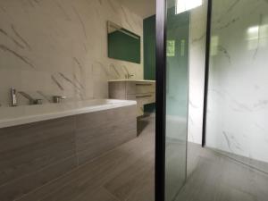 La salle de bains est pourvue d'une baignoire, d'un lavabo et d'un miroir. dans l'établissement La Rive du Doubs - 2 chambres - 5 Pers - 56, Chemin du Canal Du Rhône au Rhin, à Dole