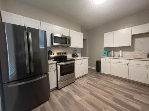 a kitchen with stainless steel appliances and white cabinets at Cozy Portsmouth Retreat 2BR 1BA in Portsmouth