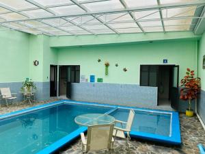 a swimming pool with chairs and a table in a building at Hotel Tres Flores in Huasca de Ocampo