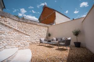 Appartement avec jardin في Pacy-sur-Eure: فناء مع كرسيين وأريكة