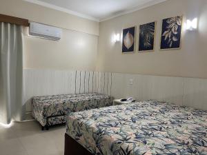 a hotel room with two beds in a room at Spazzio Di Roma - Apartamentos para Temporada in Caldas Novas