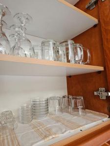 a shelf with glasses and plates on it at Athene place 1 in Rodhiá