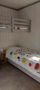 a bedroom with a bed with a colorful blanket at Chalet la landaise en bord du lac de Peyre à Labouheyre in Labouheyre +9 photos