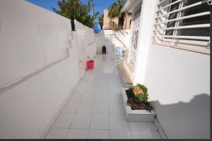 een betegelde hal met witte muren en potplanten bij Charment logement avec une terrasse privée. in Agadir