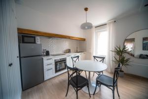 een keuken met een tafel en stoelen en een koelkast bij Appartement avec jardin in Pacy-sur-Eure