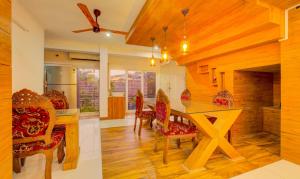 a dining room with a wooden table and chairs at NAWAL MAHAL in Cochin