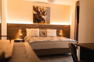 a bedroom with a bed with a picture of a deer on the wall at Maison Poluc hotel apartments in Champoluc