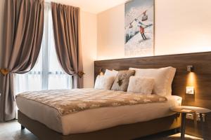 um quarto com uma cama grande e uma janela grande em Maison Poluc hotel apartments em Champoluc